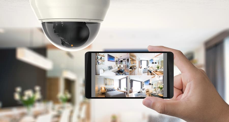 Homeowner holding smartphone with video feed from security cameras in Florence